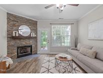 Comfortable living room featuring a stone fireplace, stylish rug, and neutral color palette at 4535 Sugarbend Way, Raleigh, NC 27606