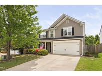 Charming two-story home boasts a well-manicured front yard, two-car garage and patriotic display at 5512 Bridgeman Ct, Durham, NC 27703