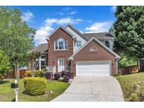 Charming two-story brick home featuring an attached two-car garage and beautifully landscaped front yard at 7 Bonham Ct, Durham, NC 27703