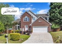 Charming two-story brick home featuring a well-manicured lawn, attached garage, and inviting front porch at 7 Bonham Ct, Durham, NC 27703