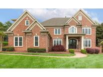 Beautiful brick home featuring a manicured lawn and an inviting, covered front entryway at 712 Evanvale Ct, Cary, NC 27518