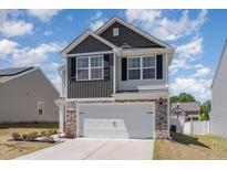 Two-story home with two-car garage, stone accents, grey siding and black shutters at 729 Little Patch St, Zebulon, NC 27597