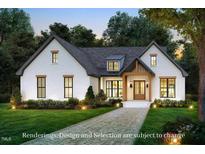 Charming white brick home with a welcoming front entrance and a well-manicured lawn at 7401 Ray Rd, Raleigh, NC 27613
