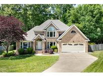 Charming two-story brick home with a well-manicured lawn and attached two-car garage at 7508 Venture Ct, Raleigh, NC 27615