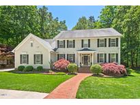 Charming two-story home with a manicured lawn, mature trees and inviting red brick walkway at 800 Oxbow Crossing Rd, Chapel Hill, NC 27516