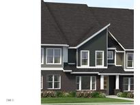 Exterior view of home with dark brick and siding, complemented by a well-maintained lawn and flowerbeds at 803 Fireship Rd, Fuquay Varina, NC 27526
