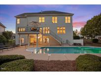Inviting backyard with a sparkling pool and a two-story home featuring an elevated deck and lush landscaping at 817 Highwater Pl, Fuquay Varina, NC 27526