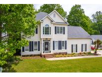 Beautiful two-story home with black shutters, tidy landscaping, and a welcoming front porch at 8600 Clivedon Dr, Raleigh, NC 27615