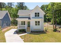 Charming two-story farmhouse with white siding, green front door, and a inviting front porch at 1013 Forrestal Pl, Durham, NC 27707