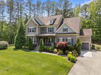Stunning two-story home with a well-manicured lawn, attached garage, and charming front porch at 1037 Lila Ln, Raleigh, NC 27614