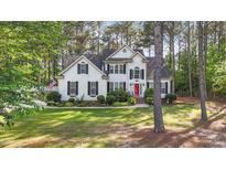 Charming two-story home with manicured lawn and a welcoming red front door at 106 Wolverton Dr, Clayton, NC 27527
