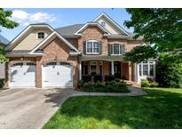 Charming brick home with a three-car garage and well-maintained landscaping in a suburban neighborhood at 12508 Angel Falls Rd, Raleigh, NC 27614