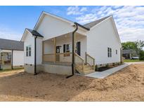 Charming single-Gathering home showcasing white siding and a welcoming front porch at 1303 Whitsett St, Burlington, NC 27217
