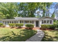 Charming single-story home with white siding, a black front door, and mature landscaping at 1314 Hudson Ave, Durham, NC 27705