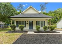 Charming home featuring a welcoming porch and meticulously manicured landscaping at 1349 Crabtree Blvd, Raleigh, NC 27610