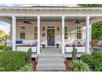 Inviting covered front porch with elegant white columns, comfortable seating, and beautiful landscaping at 1431 Courtland Dr, Raleigh, NC 27604