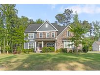 Charming two-story home with stone and siding, professional landscaping and a well-manicured lawn at 1520 Banks Brooke Dr, Raleigh, NC 27603