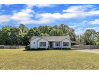 Charming home features a well-maintained lawn, tasteful landscaping, and a convenient covered parking area at 2006 Woodstone Dr, Archer Lodge, NC 27527