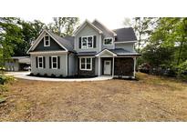 Beautiful two-story home with gray siding, black shutters, stone accents, and a well-manicured lawn at 2405 Pearces Rd, Zebulon, NC 27597