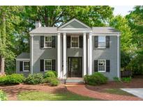 Charming two-story home with a brick walkway, black shutters, and manicured landscaping at 2704 Fairview Rd, Raleigh, NC 27608
