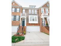 Charming brick townhouse with an attached garage and landscaped front steps at 2711 Laurelcherry St, Raleigh, NC 27612