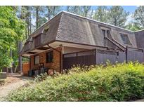 Charming townhome featuring a brick facade, cozy balcony, and lush green landscaping at 294 Summerwalk Cir, Chapel Hill, NC 27517