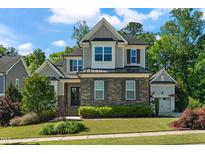 Beautiful two-story home featuring stone accents, manicured landscaping, and a charming covered entryway at 3029 Mountain Hill Dr, Wake Forest, NC 27587