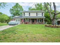 Charming two-story home with a well-manicured lawn, solar panels, and an American flag displayed at 304 Cornelia Dr, Graham, NC 27253