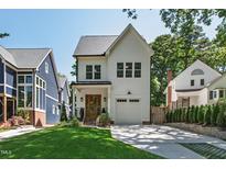 Charming white two-story home with manicured lawn and driveway, featuring a warm and inviting exterior at 308 Furches St, Raleigh, NC 27607