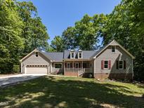 Charming home with a manicured lawn, featuring a covered front porch and attached two-car garage at 312 Heidinger Dr, Cary, NC 27511