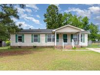 Charming one-story home features green shutters and a welcoming front porch and yard at 43 Columbus Ct, Spring Lake, NC 28390