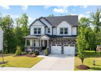 Charming two-story home with stone accents, a covered porch, and a well-manicured lawn at 521 Marion Hills Way, Knightdale, NC 27545
