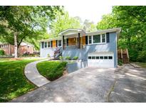 Charming home with a blue painted brick exterior, wooden accents, and an attached garage at 529 Orindo Dr, Durham, NC 27713