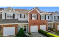 Charming townhome with a brick facade and attached one car garage at 604 Oakfield Trl, Mebane, NC 27302