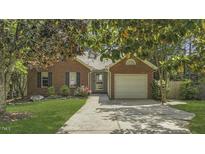 Charming brick home with mature trees, a well-maintained lawn, and a convenient two-car garage at 900 Finchurch Cir, Wake Forest, NC 27587