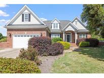 Charming brick home with manicured landscaping and a two-car garage, showcasing curb appeal at 97 Rand Rd, Raleigh, NC 27603