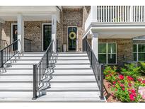 Welcoming front entrance with white stairs, black railings, and a charming brick facade at 11549 Helmond Way # 107, Raleigh, NC 27617