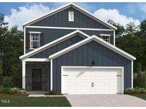 Charming two-story home featuring a white garage door and stone entryway, set against a backdrop of lush greenery at 1410 Malcus Ct # 55, Fuquay Varina, NC 27526