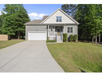 Charming home featuring a one-car garage, well-maintained lawn, and inviting front porch at 20 Paddy Ln, Youngsville, NC 27596