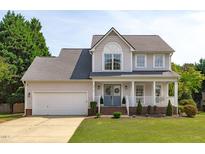 Charming two-story home featuring a garage and covered front porch with curb appeal at 2013 Waterton Ln, Apex, NC 27502