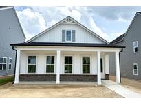 Charming new construction home featuring a stylish white exterior and inviting front porch with brick accents at 2874 Quarry Rd # 165, Rolesville, NC 27571