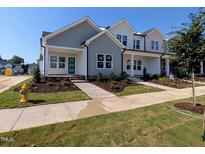 New construction home with light grey and white facade, front yard, and green door at 2911 Alyssa Ct, Raleigh, NC 27604