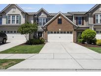Well-manicured lawn and a two-car garage enhance this two-story townhome with beautiful curb appeal at 322 Brier Crossings Loop, Durham, NC 27703