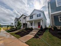 Charming two-story home featuring a welcoming front porch and a vibrant red door at 332 Cottage Hl, Knightdale, NC 27604