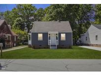 Charming single-story home with a manicured lawn, complemented by a gray exterior and a welcoming front porch at 410 Caswell St, Burlington, NC 27217