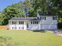 Charming two-story home with an attached garage, solar panels, and a well-maintained lawn at 4205 Woodlawn Dr, Raleigh, NC 27616