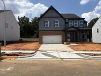 Two-story home with brick accents, a covered entry, and a two-car garage at 4317 Emeline Way # 12, Fuquay Varina, NC 27526