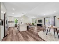 Open-concept living room and kitchen with hardwood floors and access to the outside at 4902 Cedar Glen Dr, Durham, NC 27713