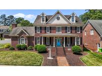 Charming two-story brick home with a blue front door, black shutters, and manicured landscaping at 5619 Bennettwood Ct, Raleigh, NC 27612