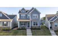 Charming two-story home with gray siding, manicured lawn, and inviting front porch and entry stairs at 636 Ginger Mint Cir, Knightdale, NC 27545